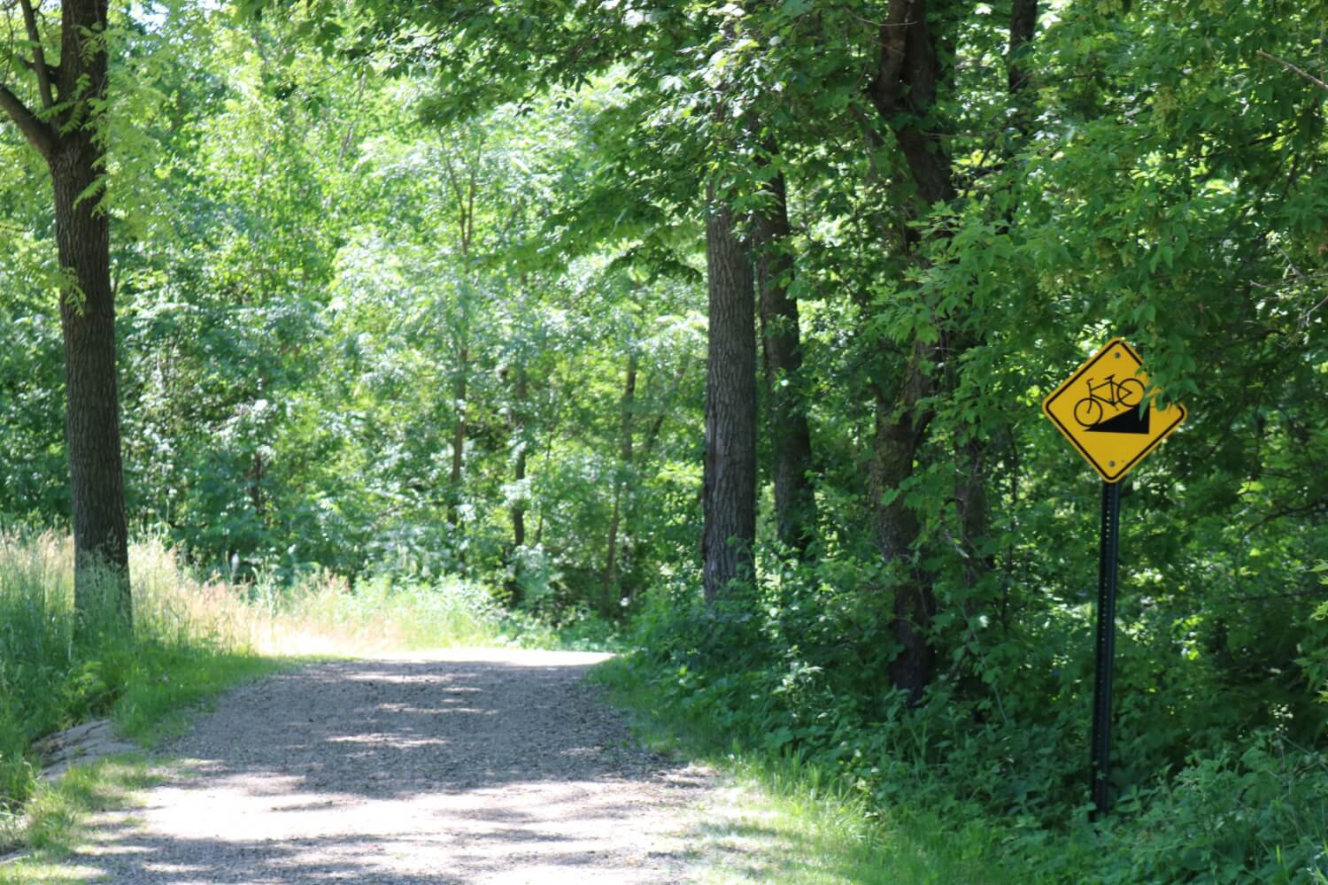 a walking/biking trail in summer athalfway creek park in holmen wisconsin