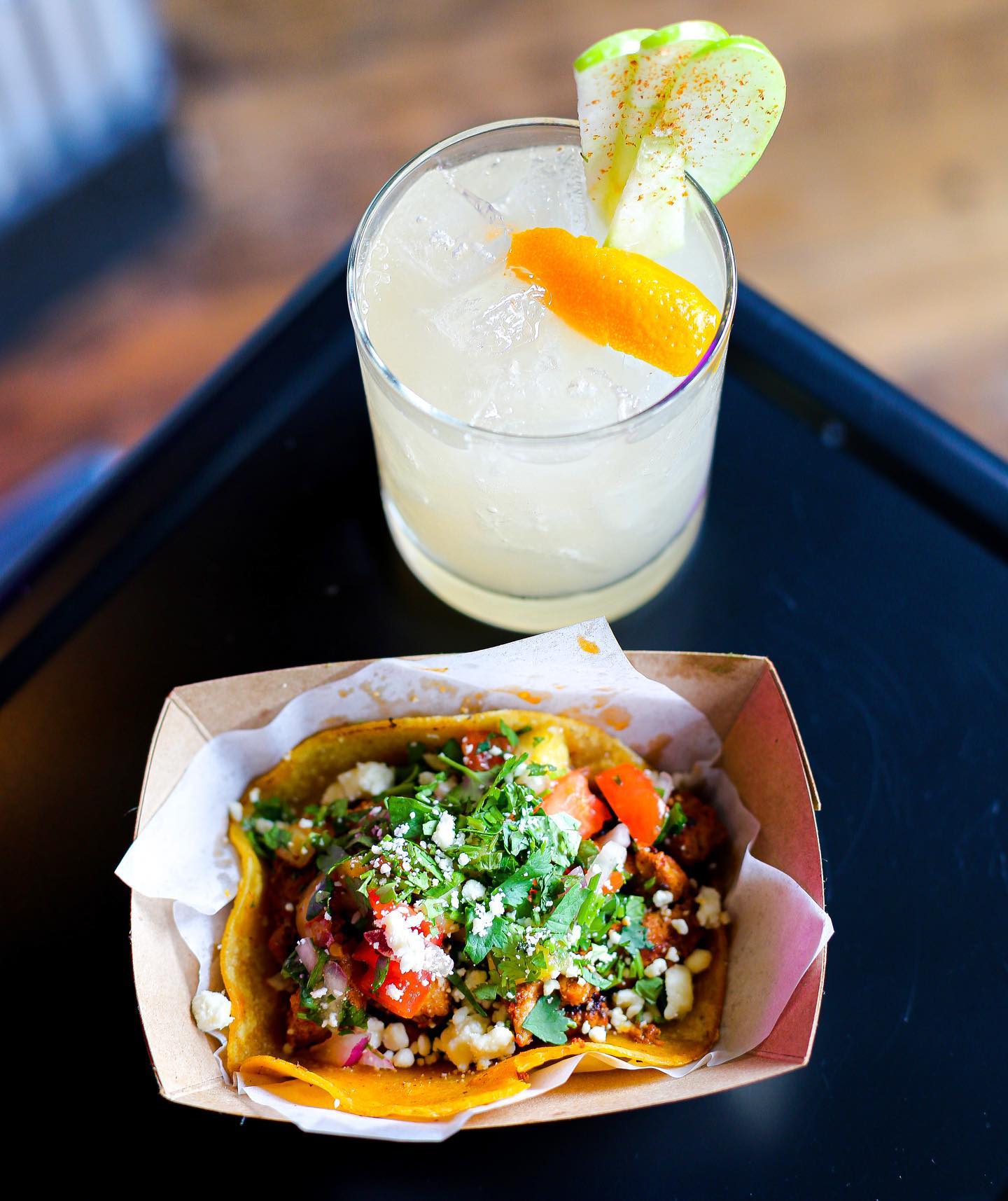 A table with a beautiful plated taco and margarita.